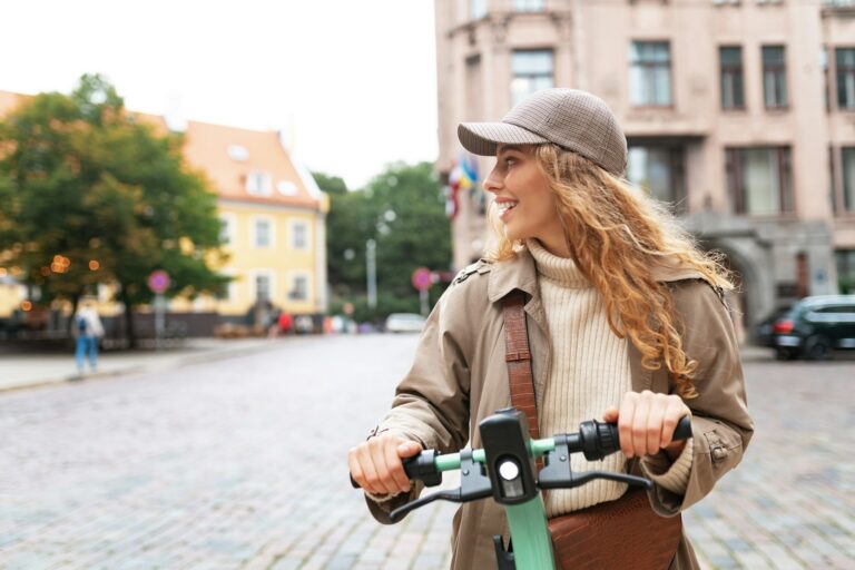 Young woman standing on electric scooter in the city